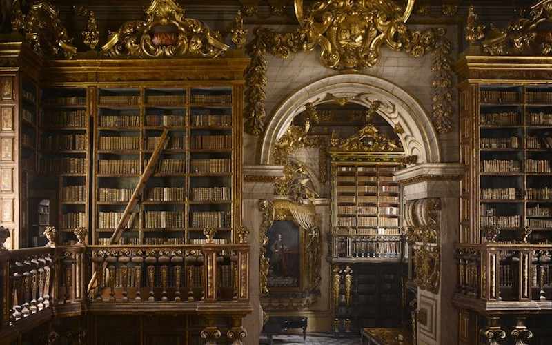 photo représentant la bibliothèque de l'universté de Coimbra, au portugal, remplis de livres très anciens