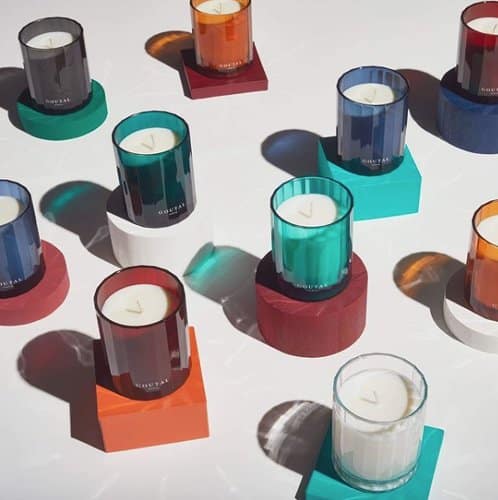 Photo de plusieurs bougies parfumées en verre de couleur, parue dans le magazine les Boomeuses