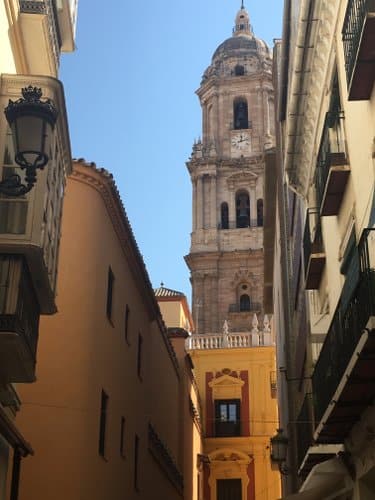 Photo de ruelles avec en fond la cathédrale de Malaga, publiée dans les Boomeuses magazine