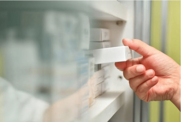 pharmacien prenant une boite pour le traitement hormonal de la ménopause, THM